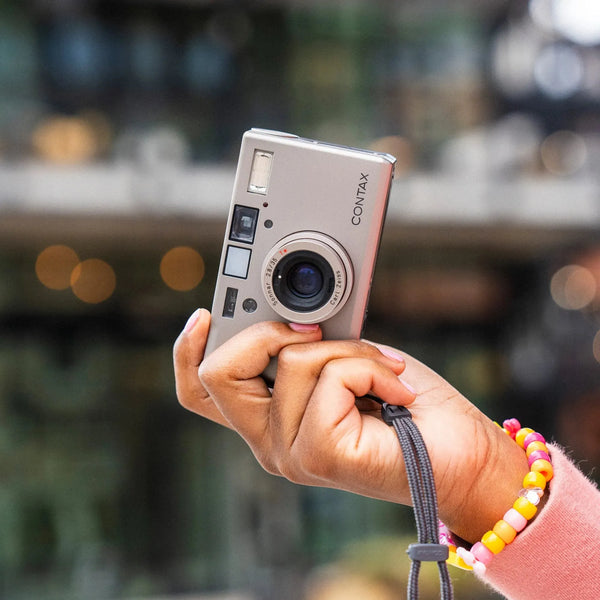 Person holding a Contax T3 35mm Point and Shoot Camera camera with a blurred background