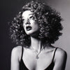 Black and white portrait of a woman with curly hair against a dark background taken with the Canon EOS 3 Film Camera