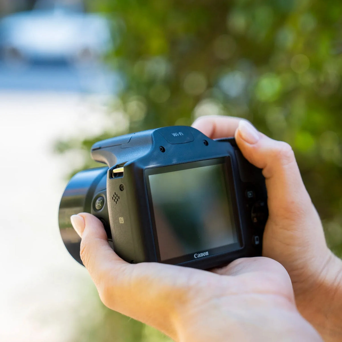 Back view of a Canon PowerShot SX530 HS being held outdoors
