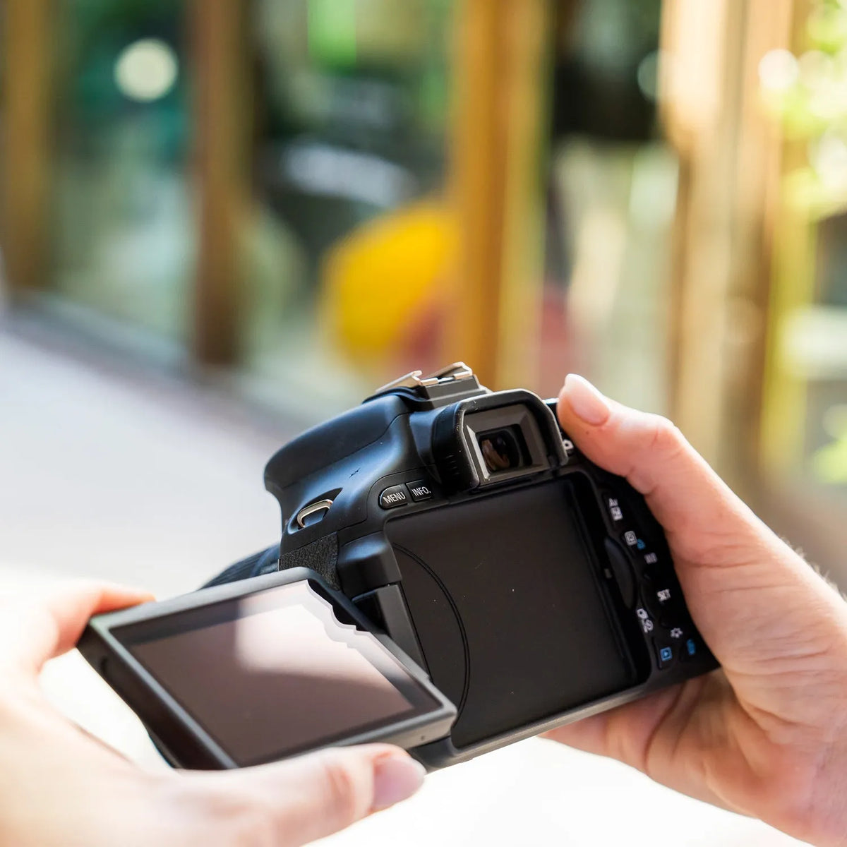 Canon Rebel T3i held with its articulating LCD screen opened