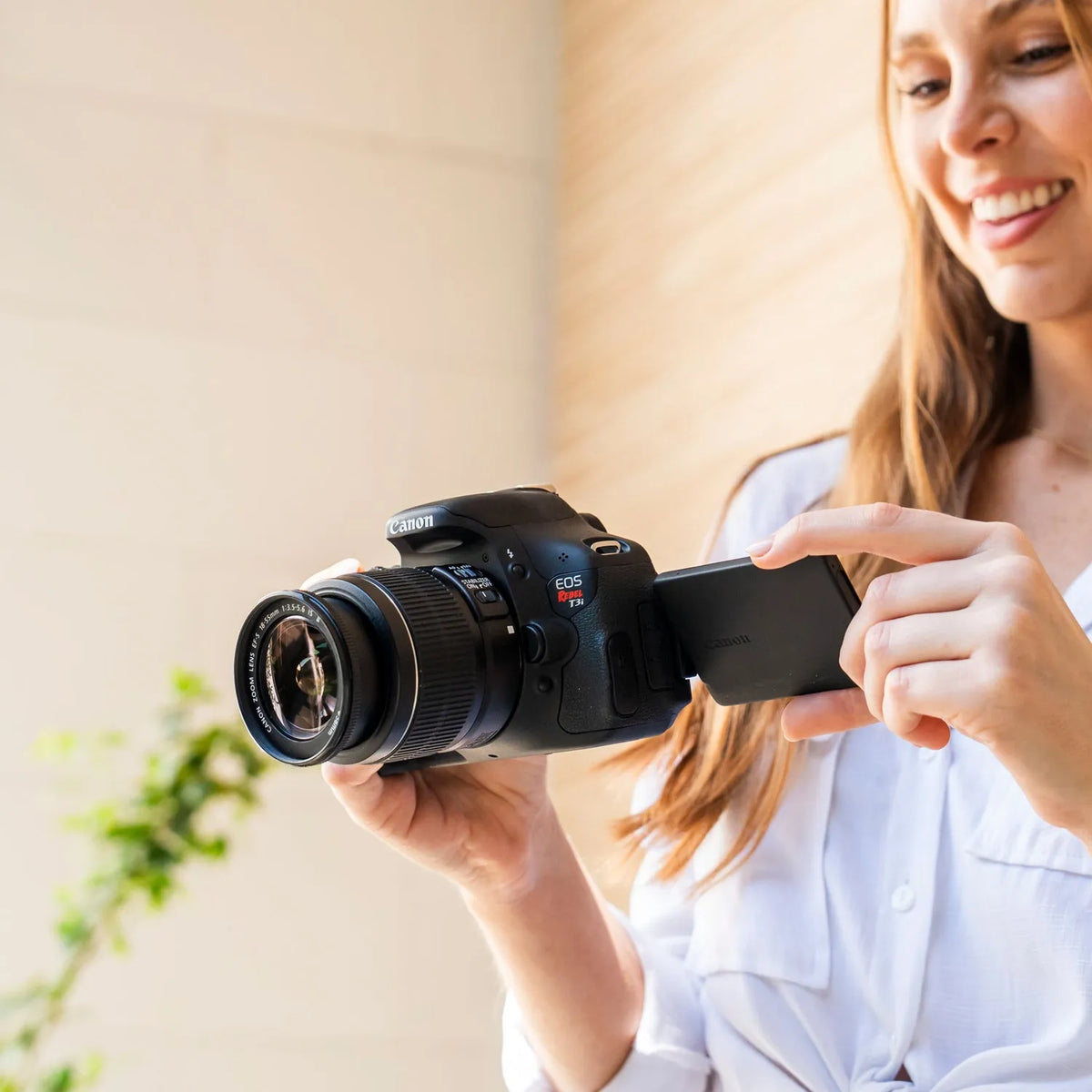 Woman reviewing the articulating LCD screen on a Canon Rebel T3i DSLR camera