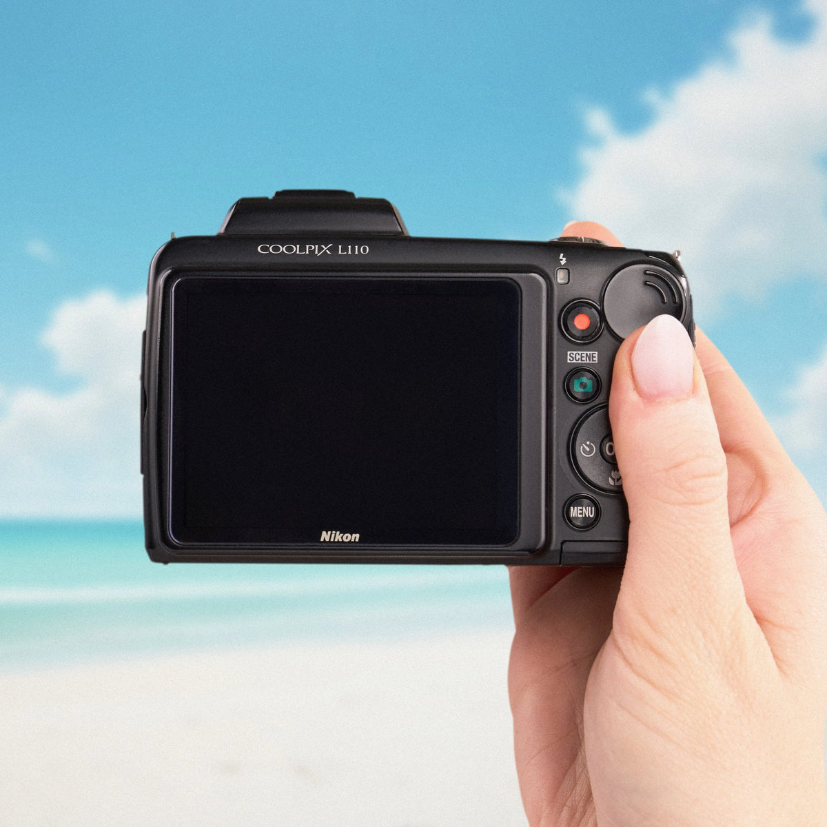 Back view of a Nikon COOLPIX L110 showing its LCD screen and controls at the beach