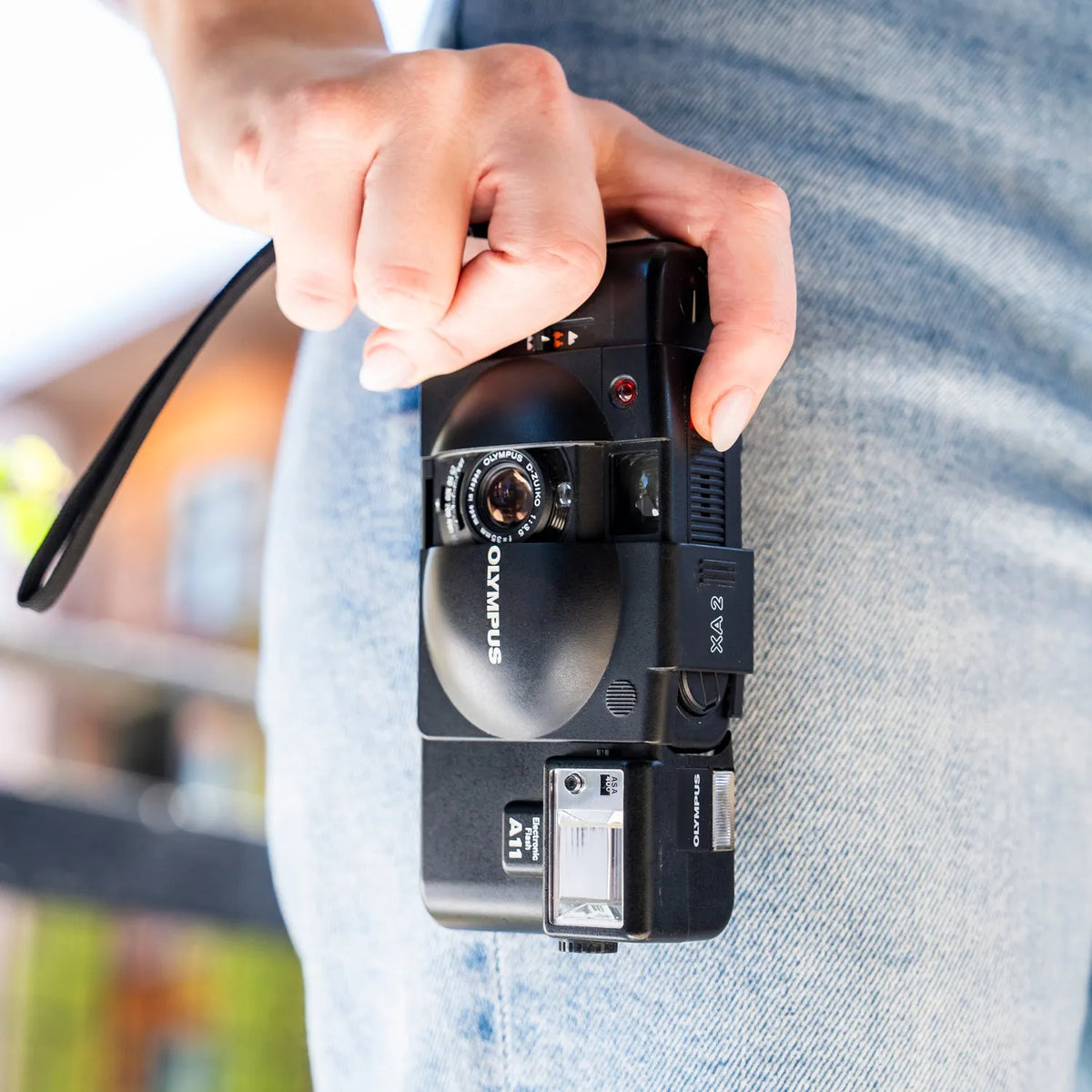 Person holding a Olympus XA 2 | 35mm Point and Shoot Film Camera with a blurred background
