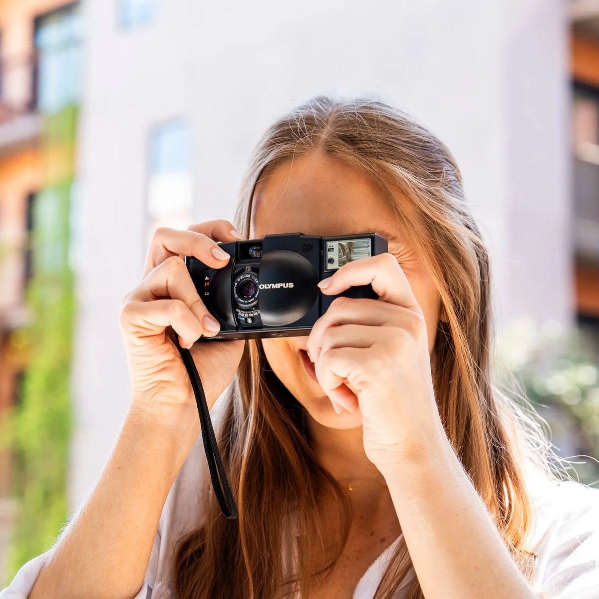 Person holding a Olympus XA 2 | 35mm Point and Shoot Film Camera with a blurred background