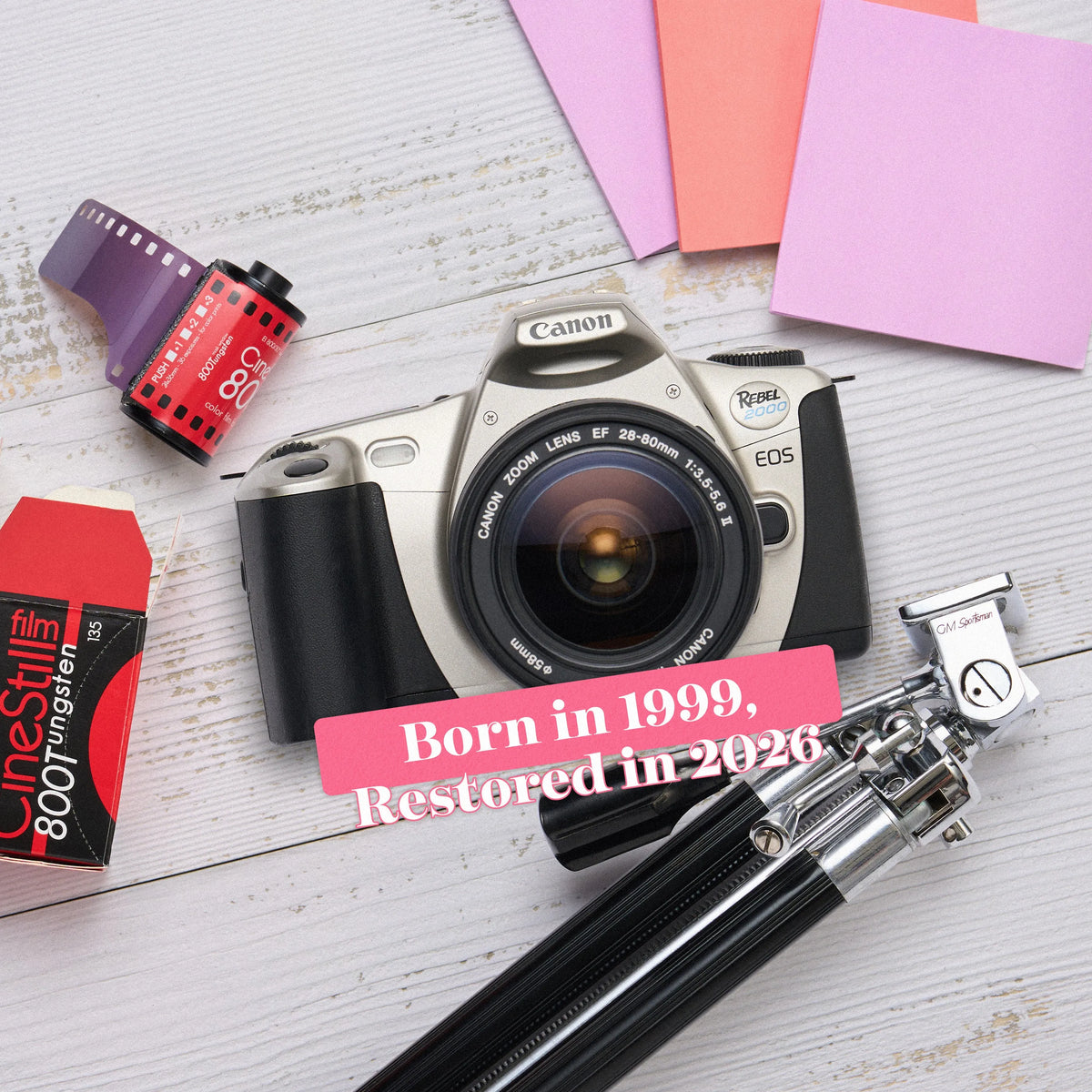 Canon EOS Rebel 2000 film camera with film and memory card on a wooden surface