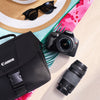 Canon Rebel T6 DSLR Camera, lens, and bag on a colorful background