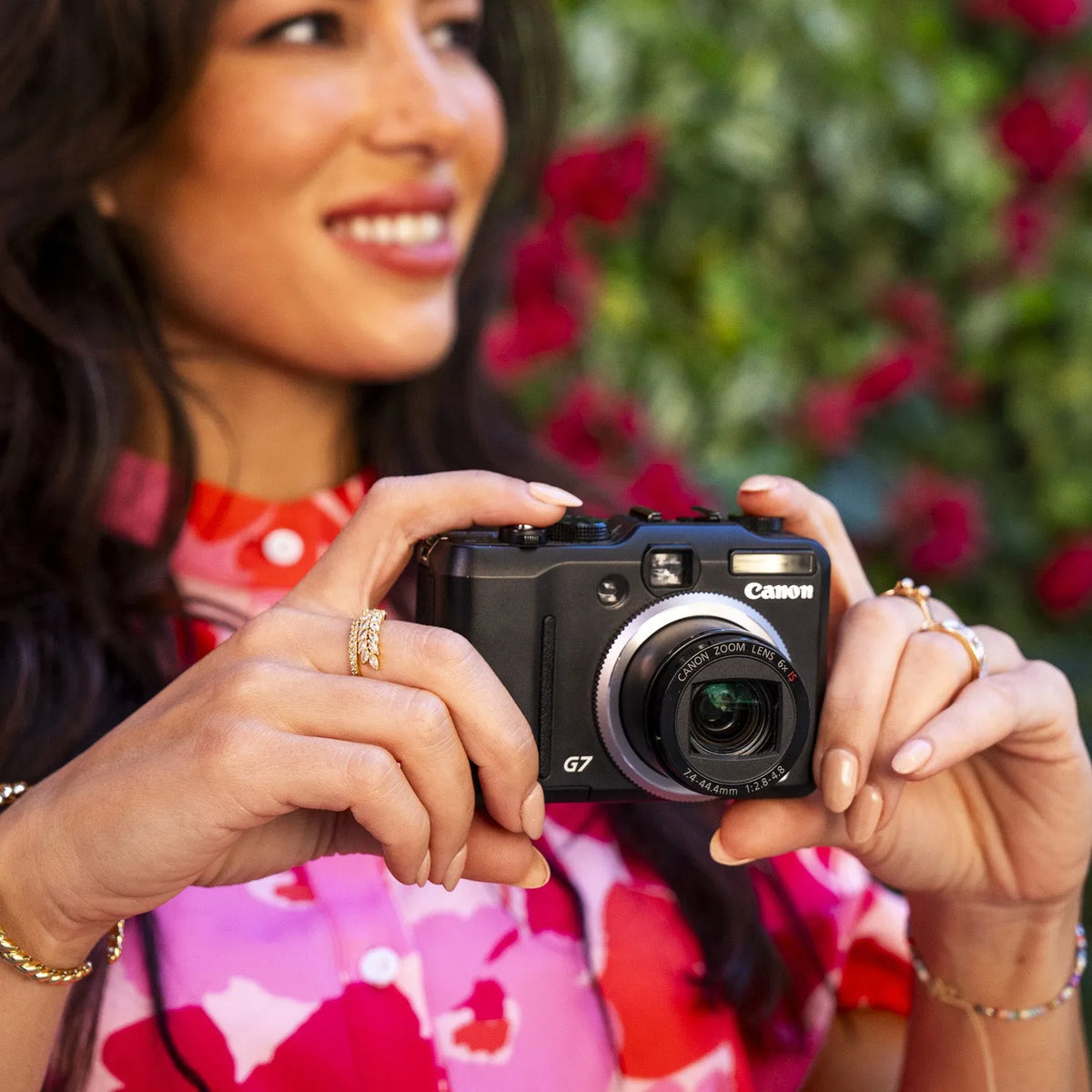 Woman holding a Canon PowerShot G7 retro point-and-shoot camera outdoors