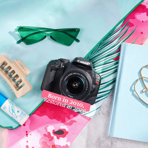 Restored Canon Rebel T2i styled with colorful accessories, labeled Born in 2010, Restored in 2026