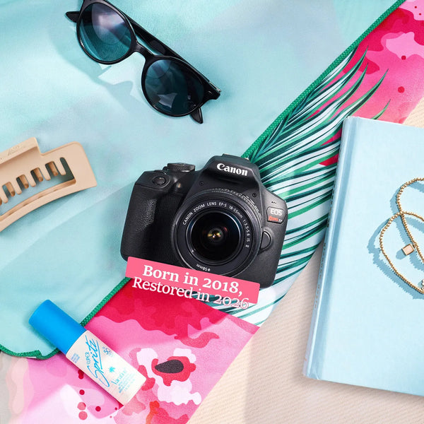 Restored Canon Rebel T7 styled with colorful accessories, labeled Born in 2018, Restored in 2026