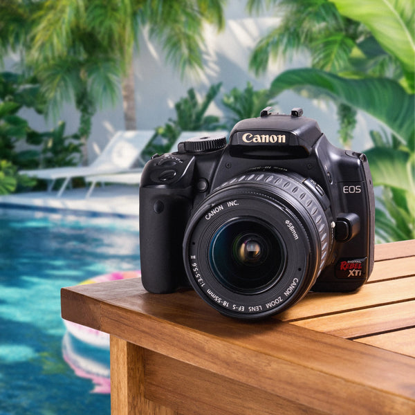 Canon Rebel XTi DSLR camera with an 18–55mm lens displayed beside a swimming pool