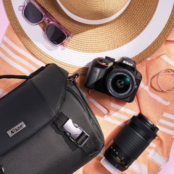 Nikon D3400 DSLR travel kit styled with a camera bag, two lenses and summer accessories