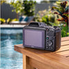 Back view of a Nikon COOLPIX L340 showing its LCD screen and controls beside a swimming pool