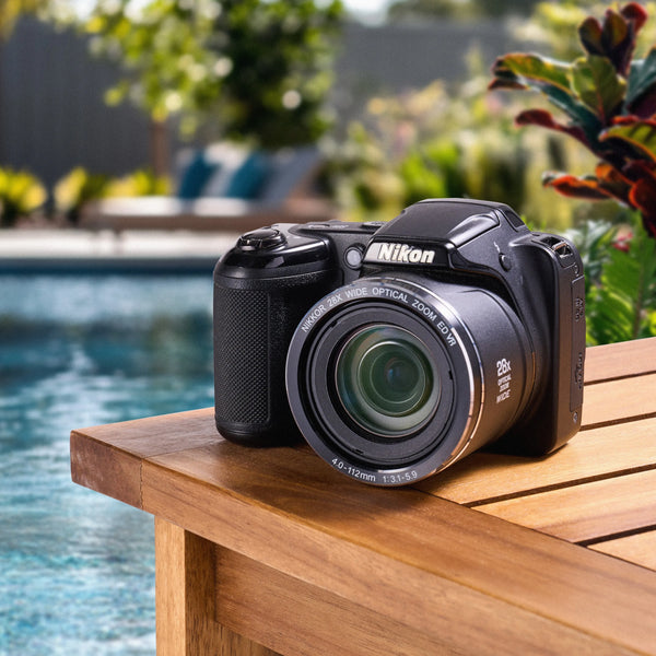 Three-quarter front view of a black Nikon COOLPIX L340 displayed beside a swimming pool