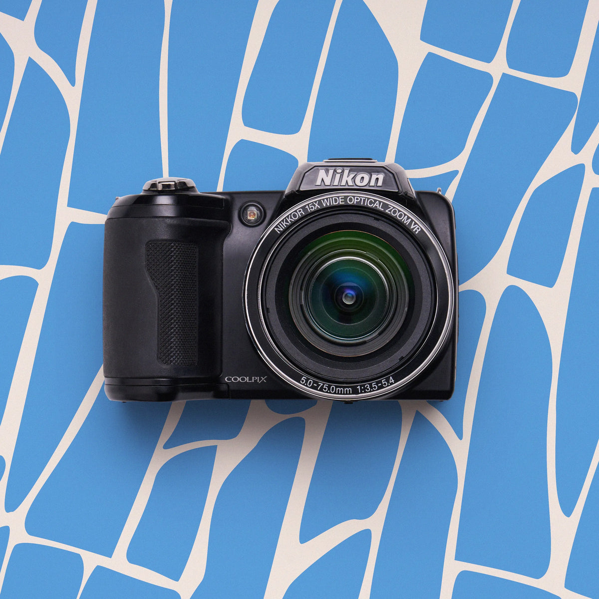 Front view of a black Nikon COOLPIX L340 superzoom camera on a blue abstract-patterned background