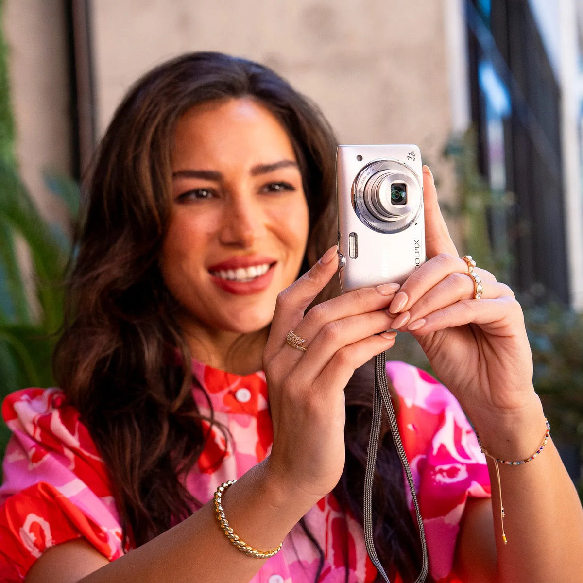 Woman holding a Nikon Coolpix s3500 outdoors with a blurred background