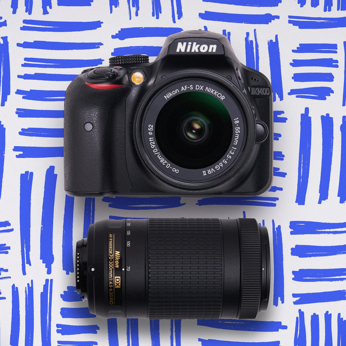 Nikon D3400 with an 18–55mm lens and 70–300mm telephoto lens on a blue patterned background