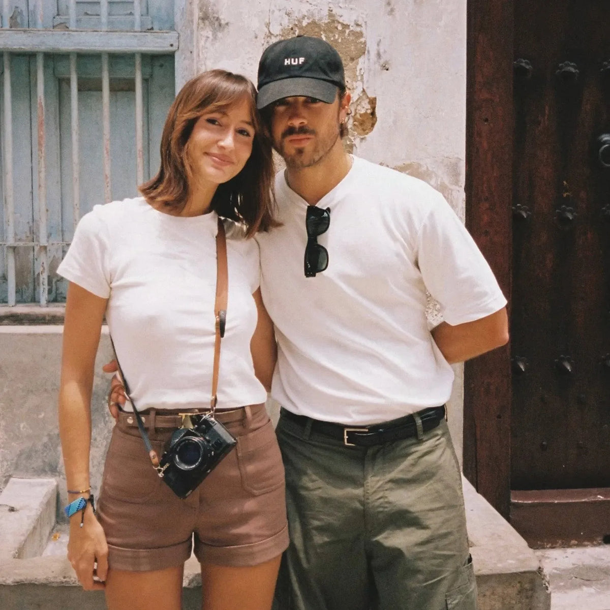 Two people standing together in front of a building, one holding a Minolta X-700 | 35mm Film Camera