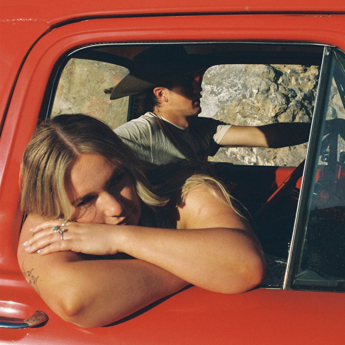 Two people in a red car with one person leaning out of the window take with the Nikon F3 35mm Film Camera