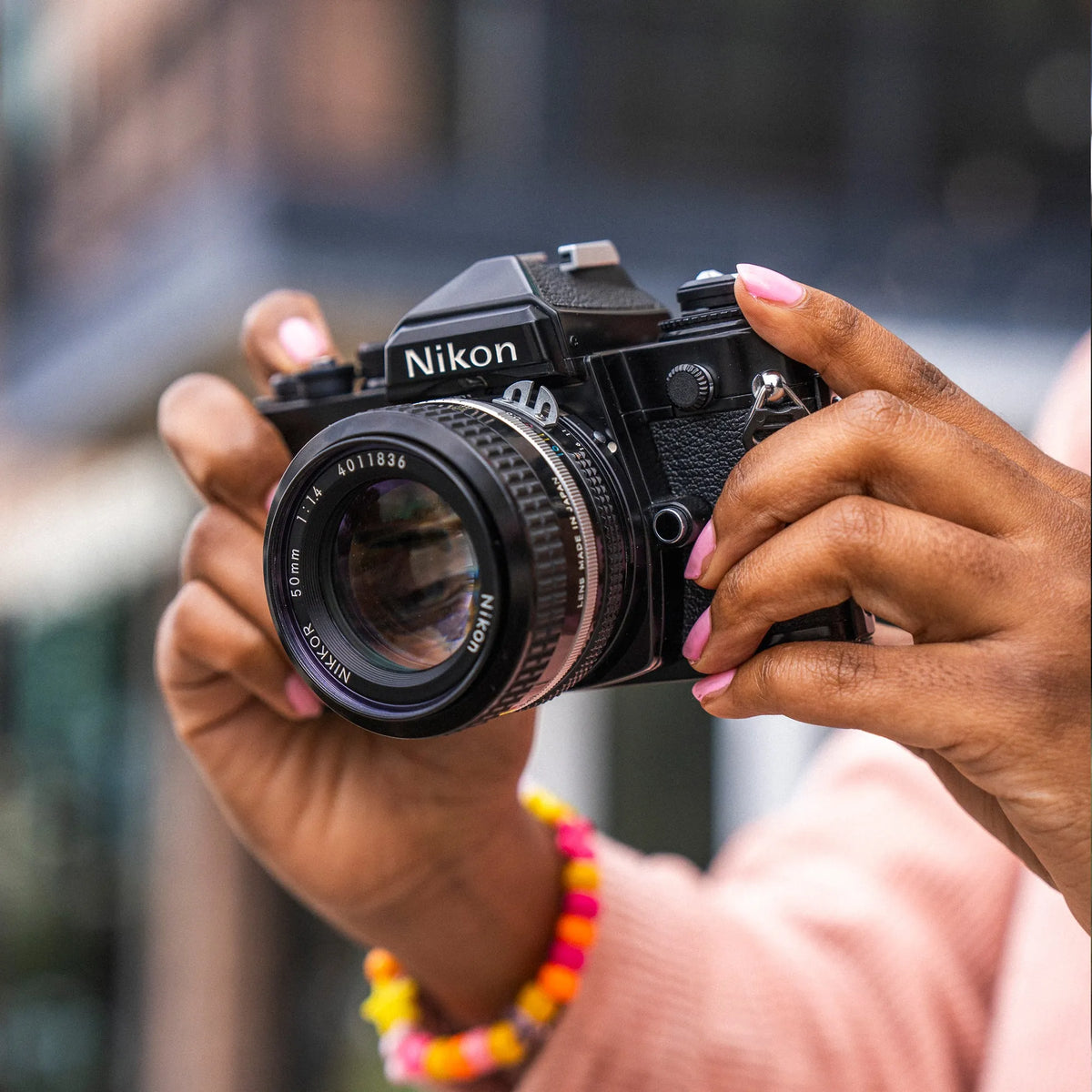 woman holding a Nikon FE 35mm Film Camera