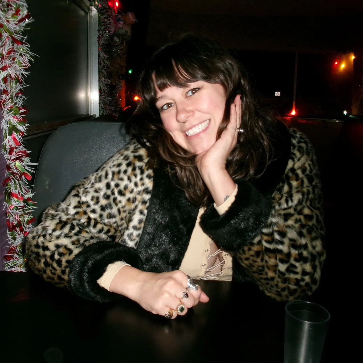 Example Nikon Coolpix S4100 flash photo of a smiling woman wearing a leopard-print coat