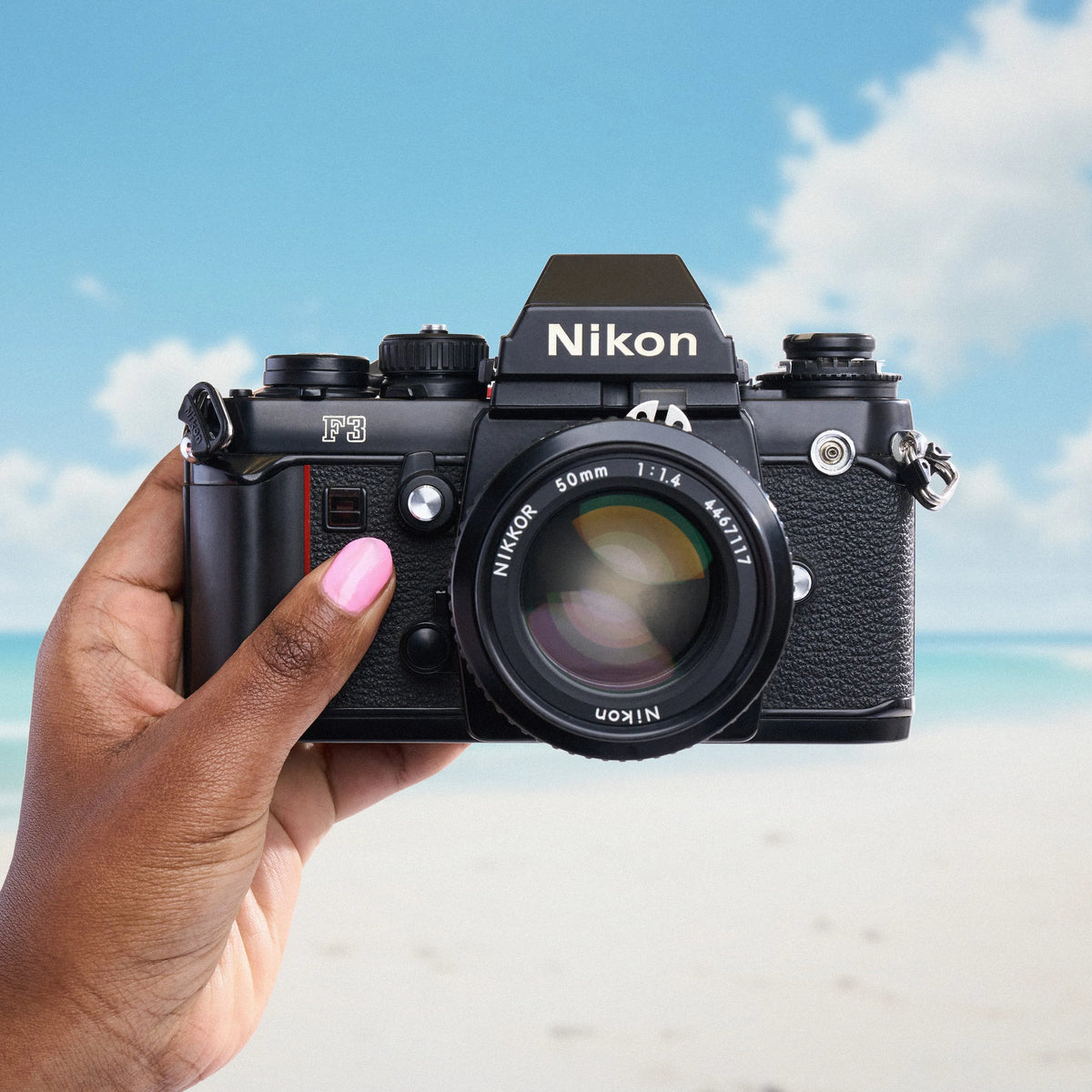 Nikon F3 35mm Film Camera held by a hand with a beach background