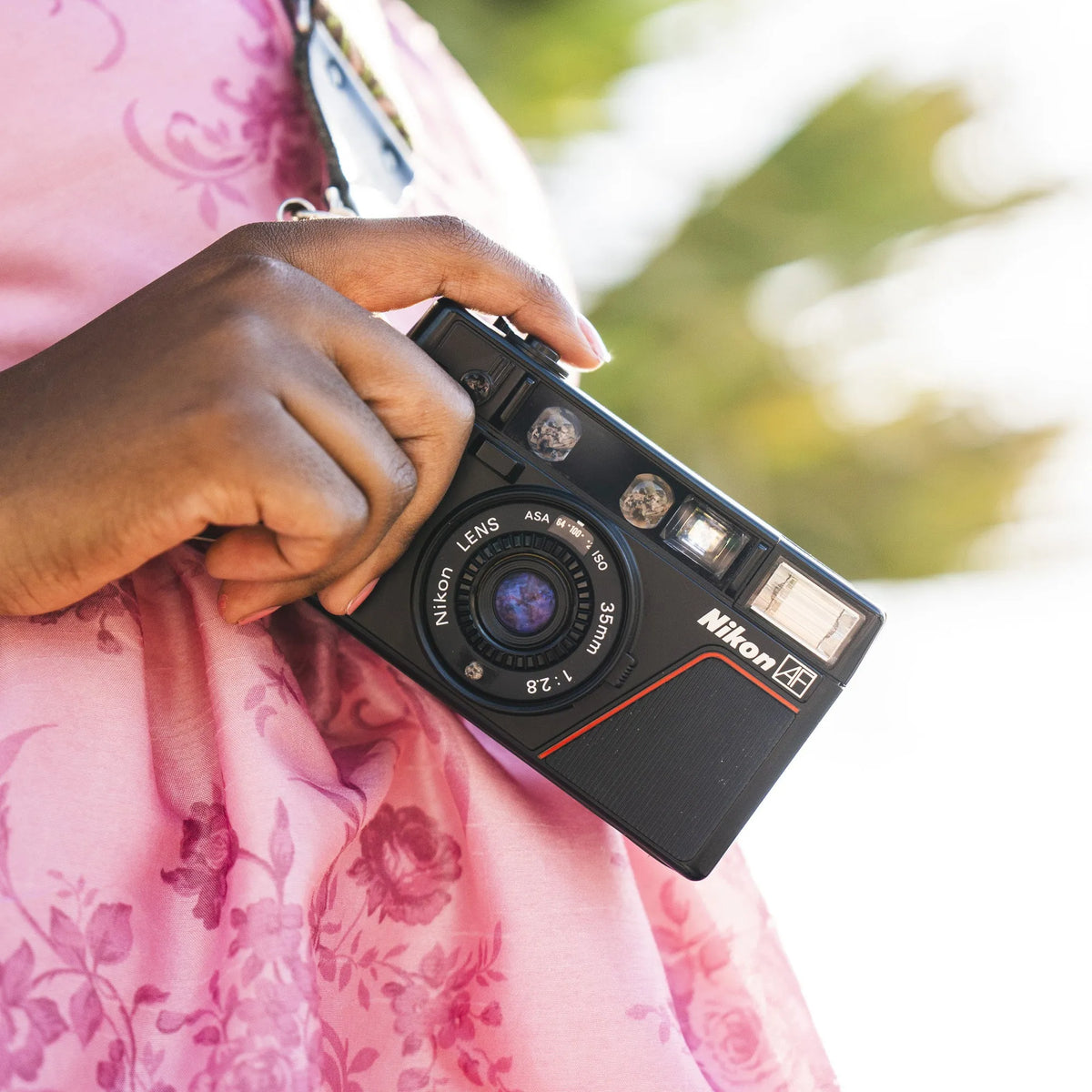 woman holding the Nikon L35AF 35mm Point and Shoot Camera