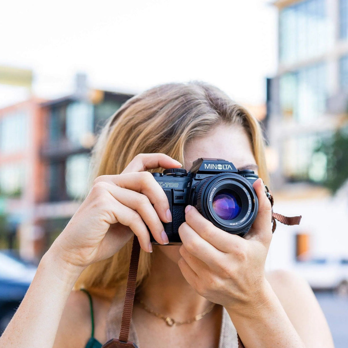 Person holding aMinolta X-700 | 35mm Film Camera in an urban setting