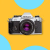 A vintage Nikon FG SLR film camera with a silver body and black textured grip, shown from the front with a 50mm lens. The camera is centered on a bright yellow background with abstract light blue circular shapes.